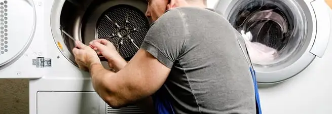 Dryer repair technician fixing a clothes dryer drum in Tuscaloosa, AL