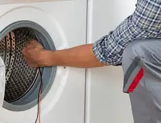 Dryer repair technician diagnosing and servicing a clothes dryer in Tuscaloosa, AL