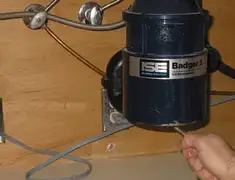 Garbage disposal repair technician tightening the mounting ring under a sink in Tuscaloosa, AL