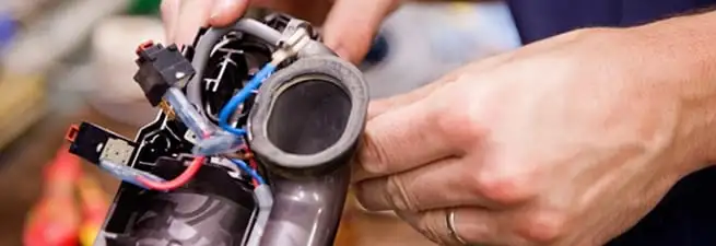 Vacuum repair technician reconnecting wiring and components in Tuscaloosa, AL