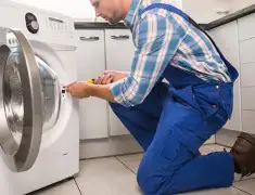 Washing machine repair technician servicing a front-load washer in Tuscaloosa, AL